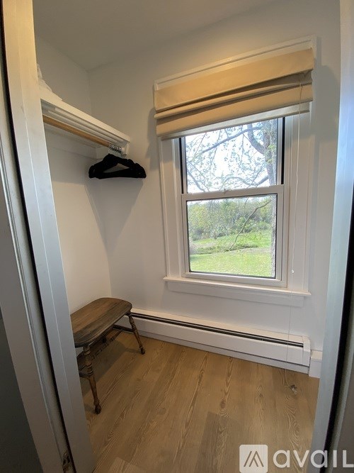 A small room with a window and a bench.
