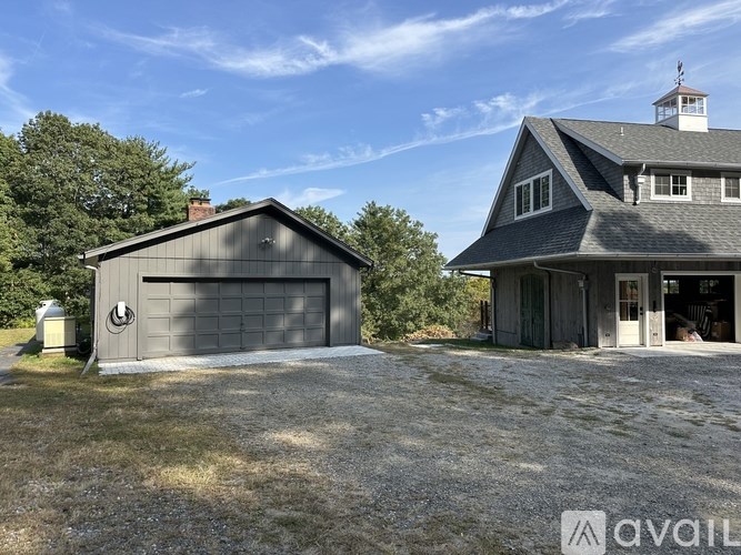 A house with a garage and a gravel driveway is for sale.