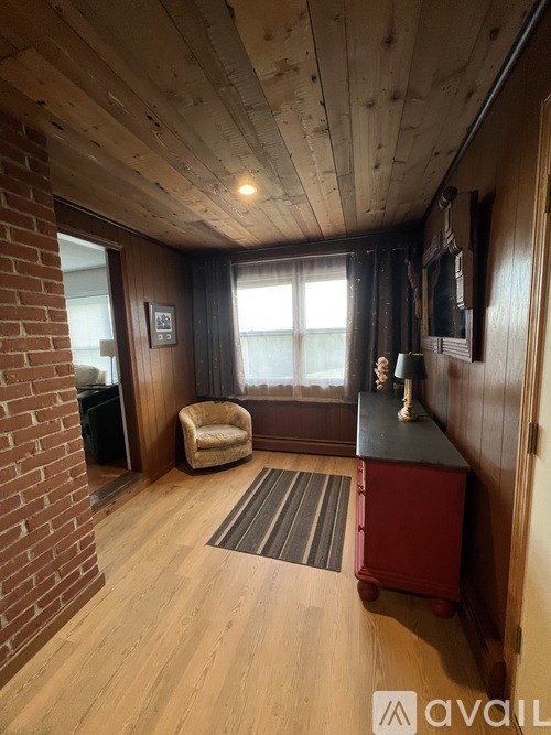 A room with wooden floors and a brick wall.