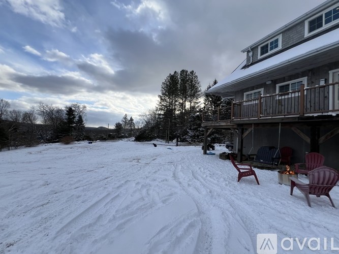 A house with a snow-covered ground and a cloudy sky.