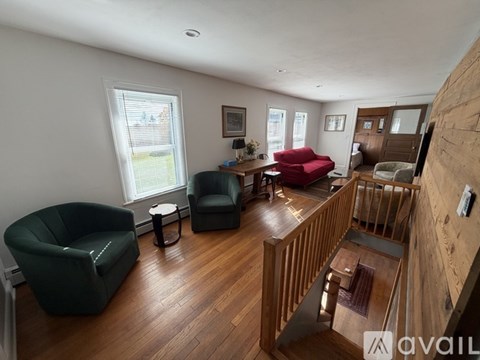 A living room with a red couch and green armchairs.