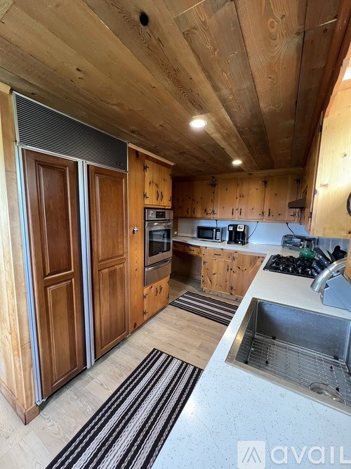 A kitchen with wooden cabinets and a stainless steel sink.