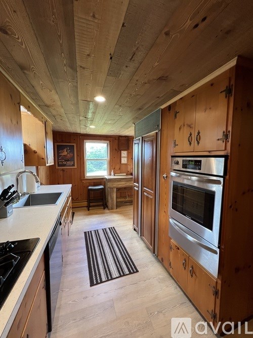 A kitchen with wooden cabinets and a stainless steel oven.