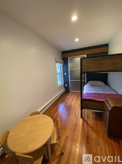 A room with a bed, a table and chairs.