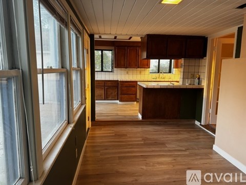A kitchen with wooden cabinets and a countertop is available for rent.
