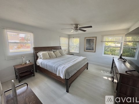 A bedroom with a large bed and a ceiling fan.