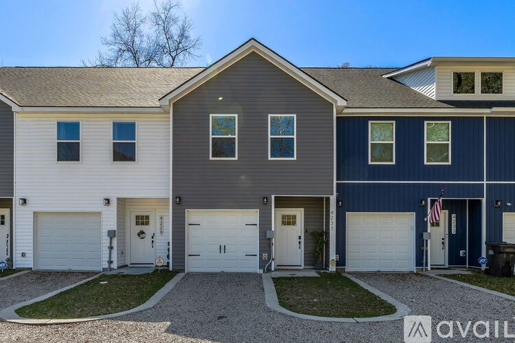 A row of houses with garages and driveways.