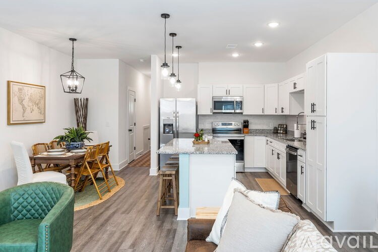 A kitchen with white cabinets and a dining table with chairs.