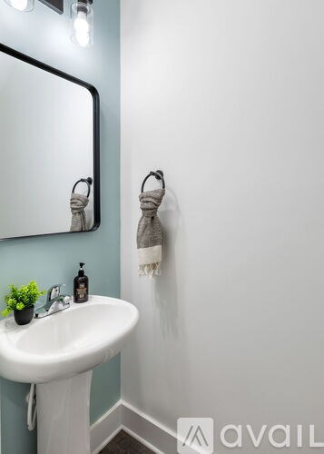 A bathroom with a white sink and a mirror.