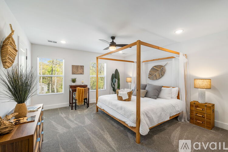 A bedroom with a four poster bed and a ceiling fan.