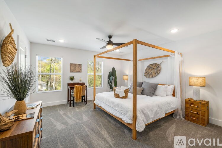 A bedroom with a four poster bed and a ceiling fan.