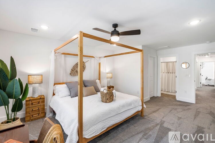 A bedroom with a four poster bed and a ceiling fan.