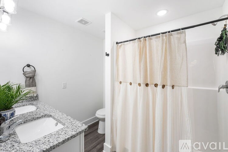 A bathroom with a sink, toilet, and shower curtain.