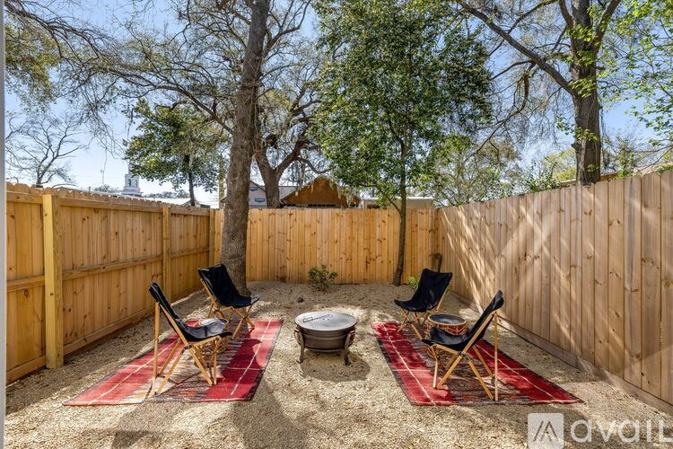 A backyard with a fire pit and chairs.