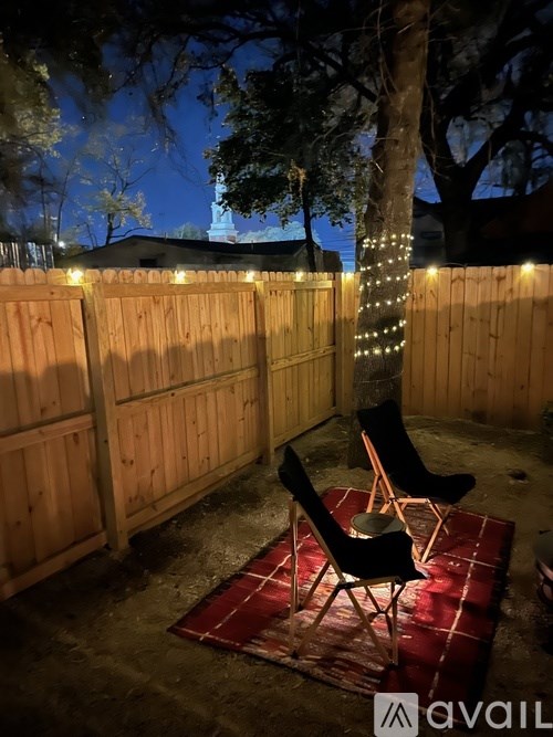 A backyard with a fence, a chair, and a blanket.