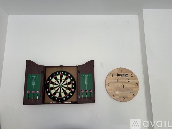 A dartboard is mounted on a wall next to a wooden board with numbers.