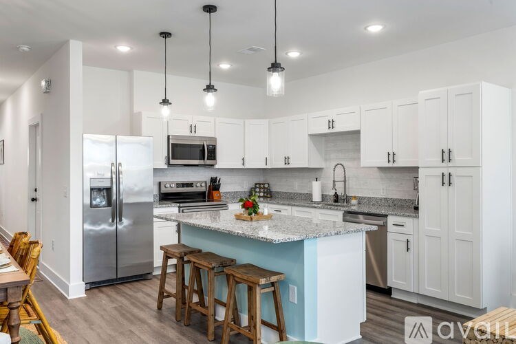 A kitchen with white cabinets and a blue island.