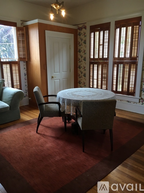 A living room with floral wallpaper and furniture from North Coast Rentals, LLC.
