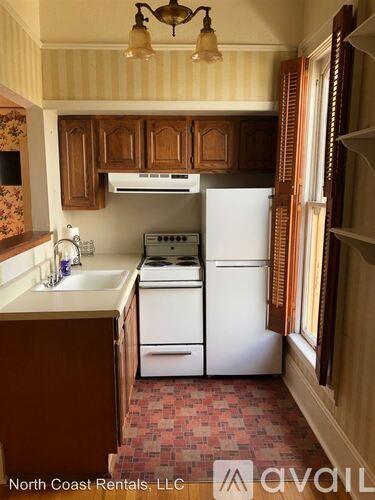 A kitchen with a white fridge and stove top oven.