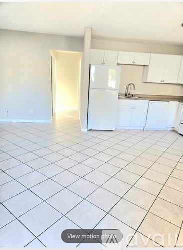 A kitchen with white appliances and wooden floors.