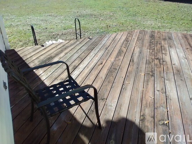 A wooden deck with a bench and a metal railing.