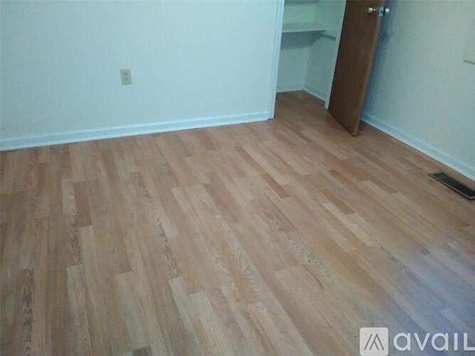 A room with wooden flooring and a door on the right.