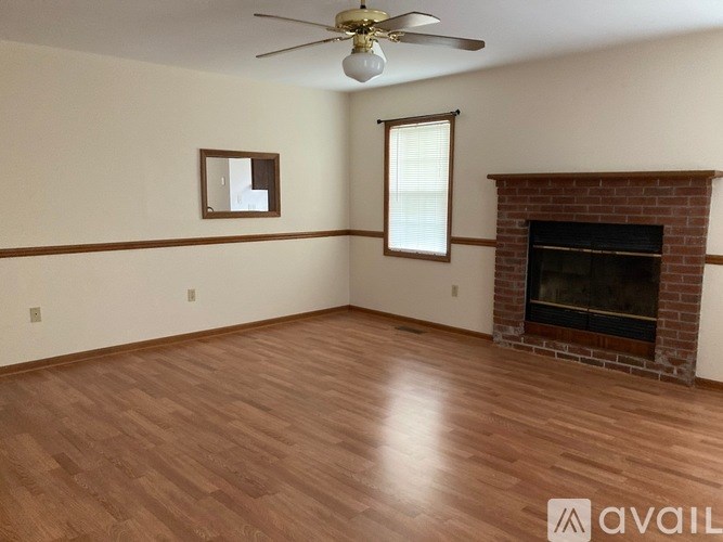 A room with a fireplace and a ceiling fan.