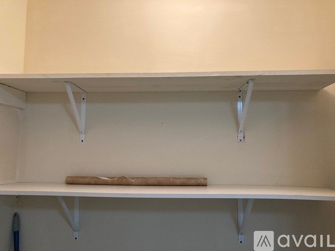 A white shelf with a wooden board on it.
