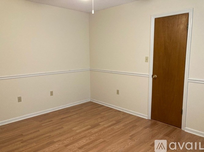A room with a wooden door and baseboard heating.