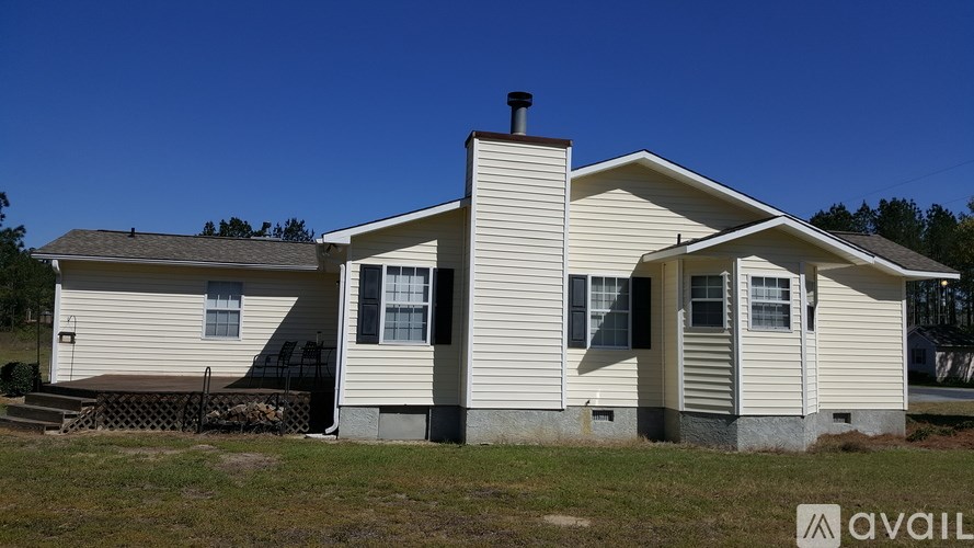 A house with a white exterior and a brown roof is available for purchase.