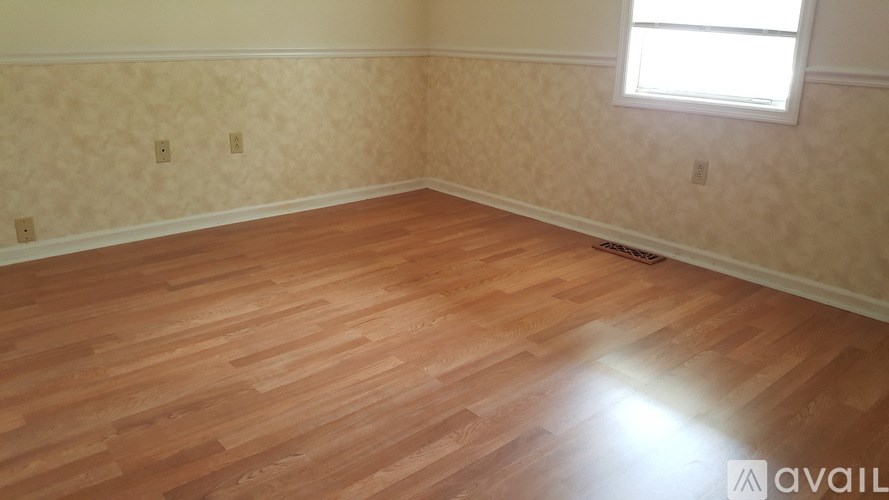 A room with wooden flooring and a window.