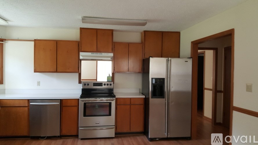 A kitchen with brown cabinets and stainless steel appliances.