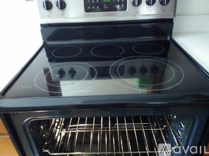 A modern stove with a glass top and a digital control panel is shown.