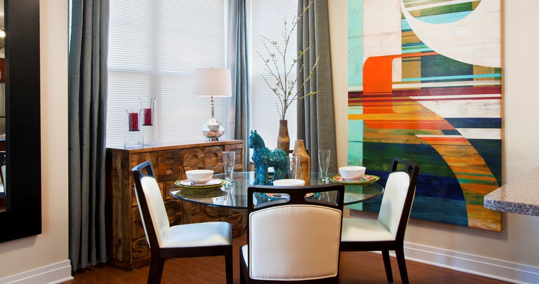 a dining room with a table and chairs and a painting