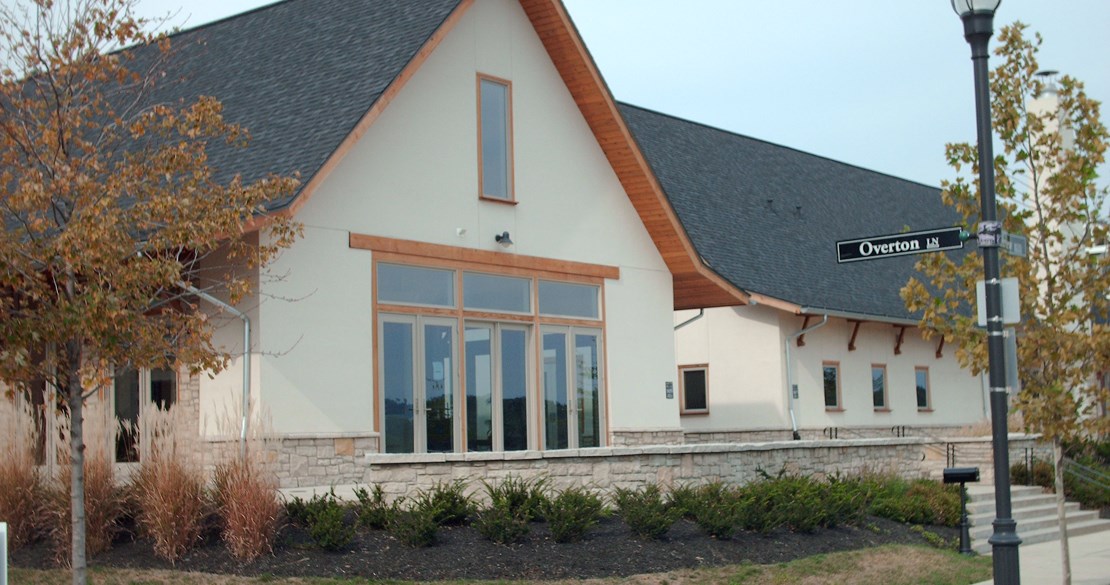 a white house with large windows and a street sign