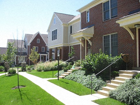 a sidewalk in front of a row of houses