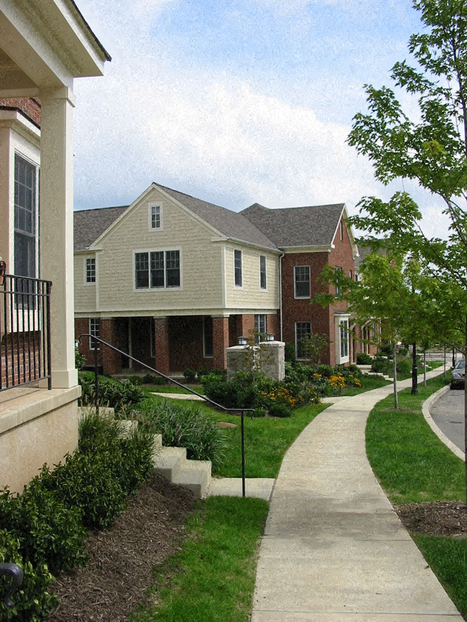 a sidewalk in front of a row of houses