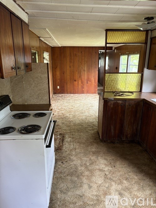 A kitchen with a white stove and wooden cabinets.