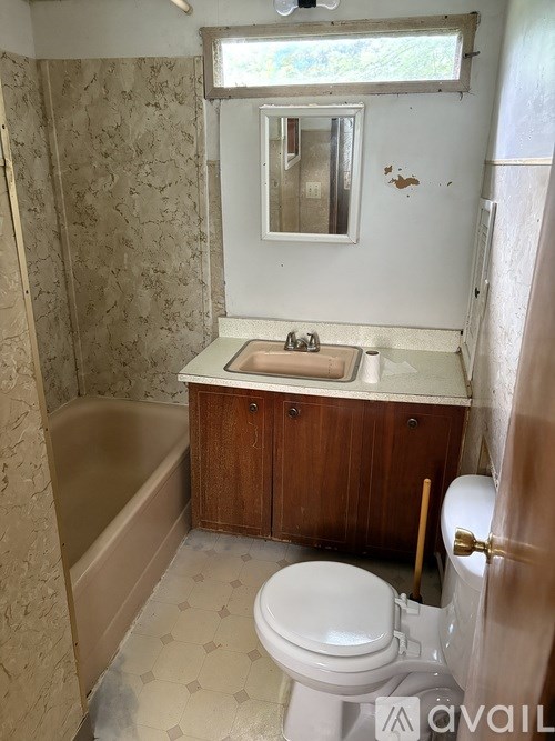 A bathroom with a toilet, sink, and bathtub.