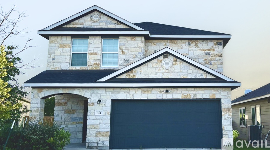 A two-story house with a garage door is available for sale.