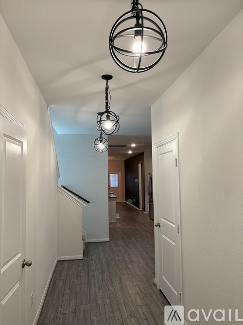 A hallway with a light fixture hanging from the ceiling.