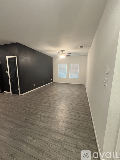 A room with wooden flooring and a ceiling fan.
