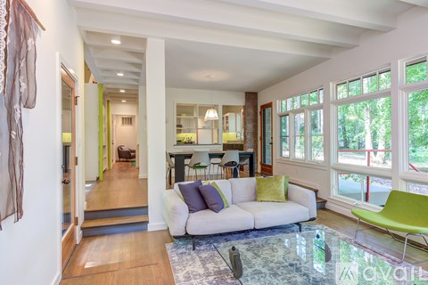 A living room with a white couch and a glass table.