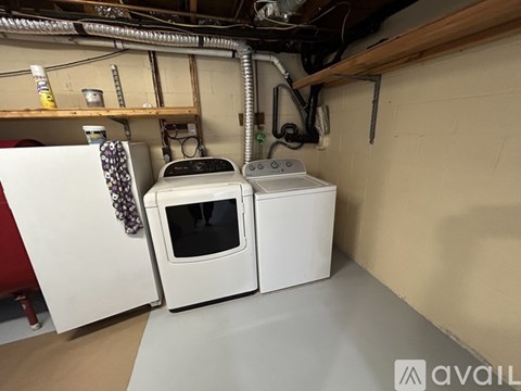 A white microwave oven is placed next to a white toaster oven in a kitchen.