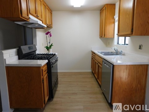 A kitchen with wooden cabinets and a black stove top oven.