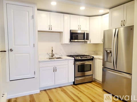 A kitchen with white cabinets and stainless steel appliances.