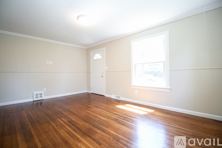 A room with wooden floors and a window letting in light.
