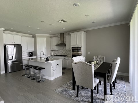 A kitchen with a dining table and chairs.