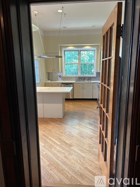 A kitchen with white cabinets and a window.