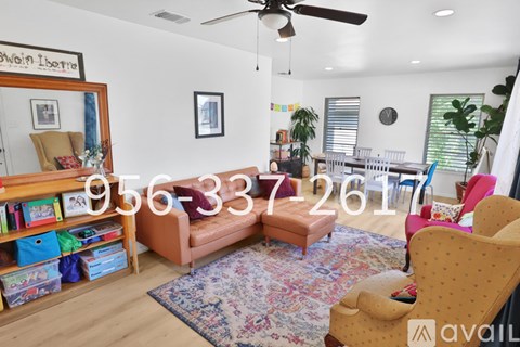 A living room with a yellow chair and a rug.